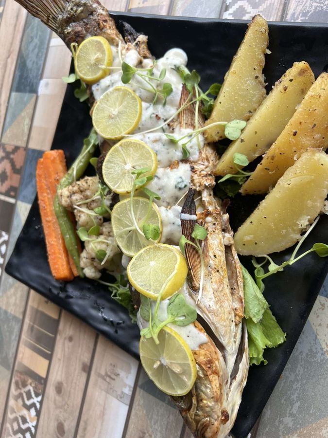 Peixe inteiro grelhado com limão siciliano e batatas
