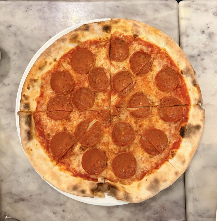Pizza de pepperoni com borda alta e tostada no forno a lenha